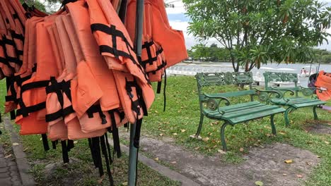 rotating life jackets on a stand in a park.