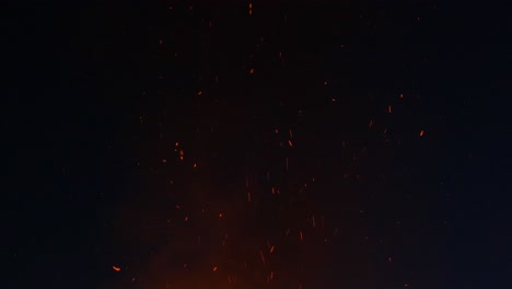 cinders on black background with some flames