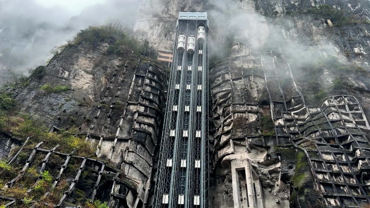 The Tiankeng Cliff Elevator Stands Against Towering Karst Rock Formations In Wulong Karst National Geology Park, Chongqing, China. Tilt-up Shot