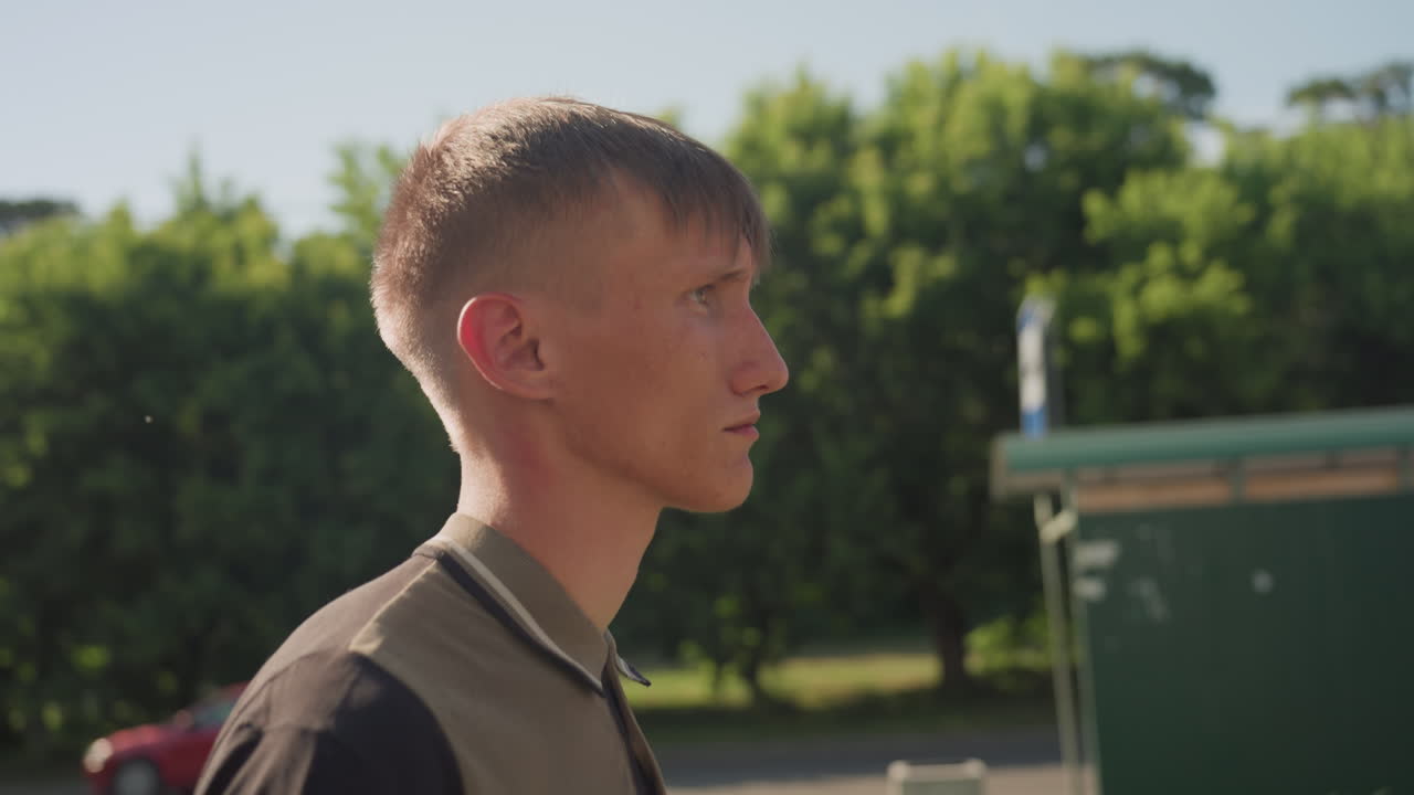 Young Man Cautiously Observes Environment, Alert Young Individual Inspects Urban Surroundings Carefully, Young Man Watches Attentively Over Rough Urban Environment From Edge Of Alleyway