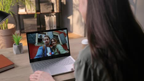 Over-Shoulder-Close-Up-View-Of-Girl-Having-Video-Call-With-Friends-And-Waving-Her-Hand