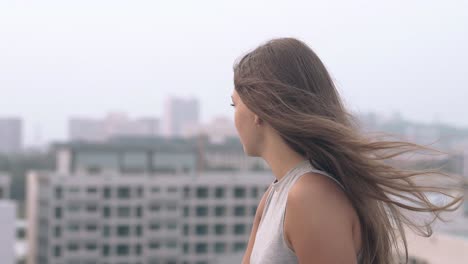 pretty-lady-looks-at-camera-and-smiles-against-city-line