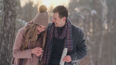 Verliebtes-Paar-Im-Winterwald,-Um-Tee-Aus-Einer-Thermoskanne-Zu-Trinken.-Stilvoller-Mann-Und-Frau-In-Einem-Mantel-Im-Park-Im-Winter-Für-Einen-Spaziergang.