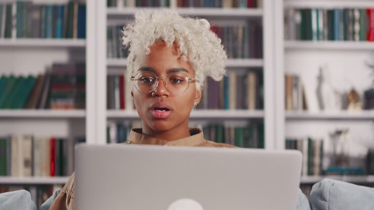 Young african american woman with laptop on lap overjoyed winning competition