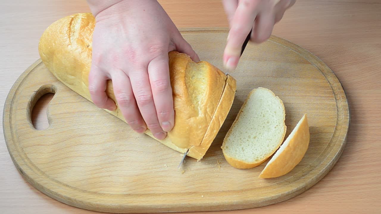 Cutting of bread. Cutting of bread on a board