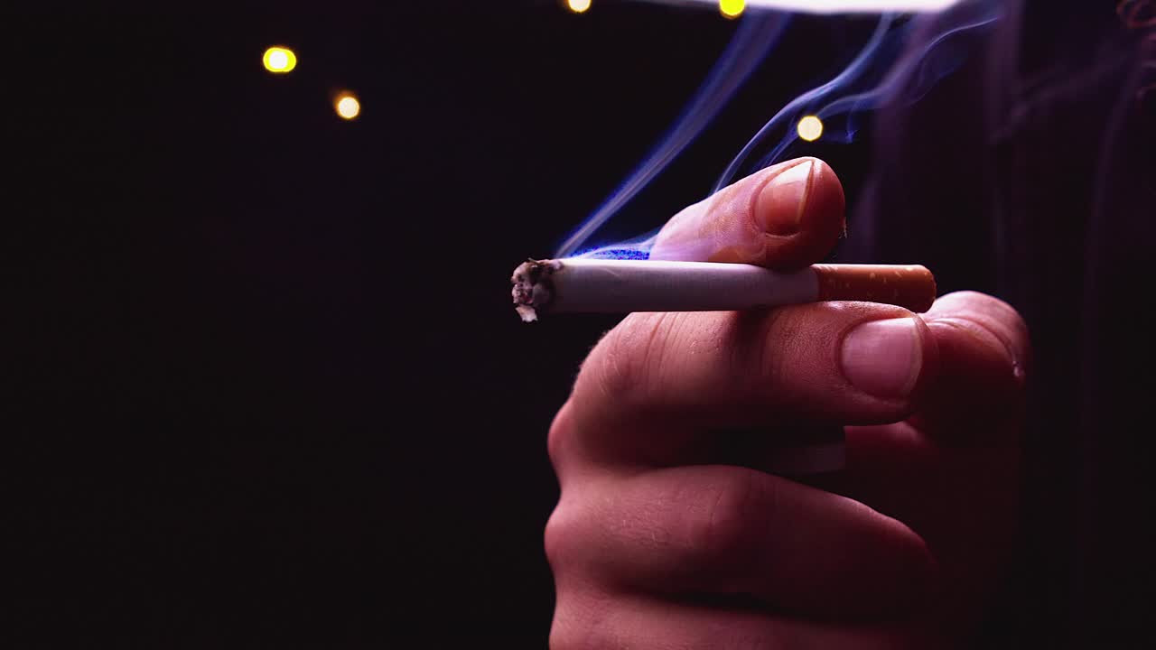 Close-up of a Hand Holding a Burning Cigarette