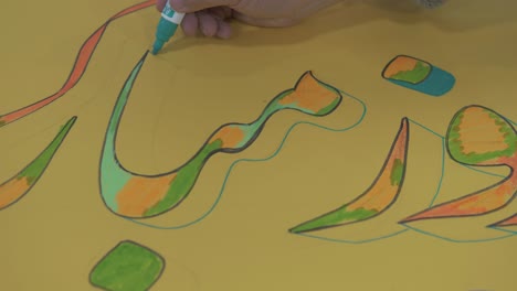 man drawing calligraphy with marker in farsi