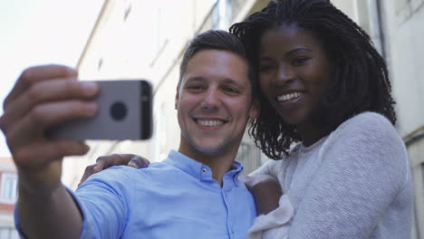happy young multiracial couple posing for selfie outdoor.