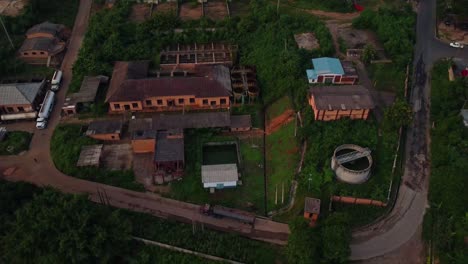 drone flies down over dirt roads, silo, enclosures, and a house in rural ibadan, oyo state, nigeria. an hydro dam site in africa