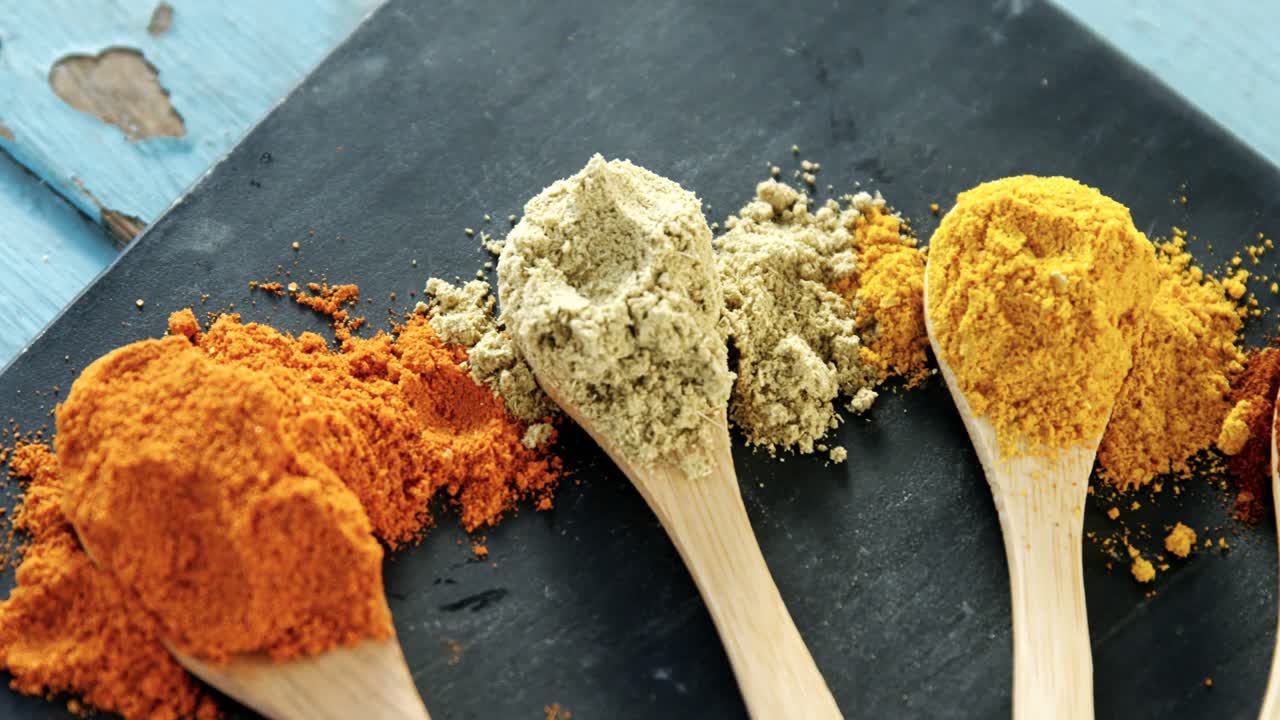 varios polvos de especias en cuchara de madera 4k