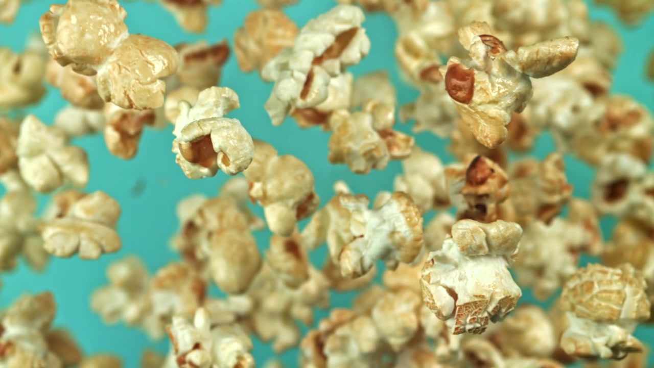 Delicious Popcorn Floating Against a Teal Background
