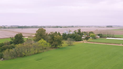 aerial - beautiful lush, fertile fields and grain silos, forward tilt up