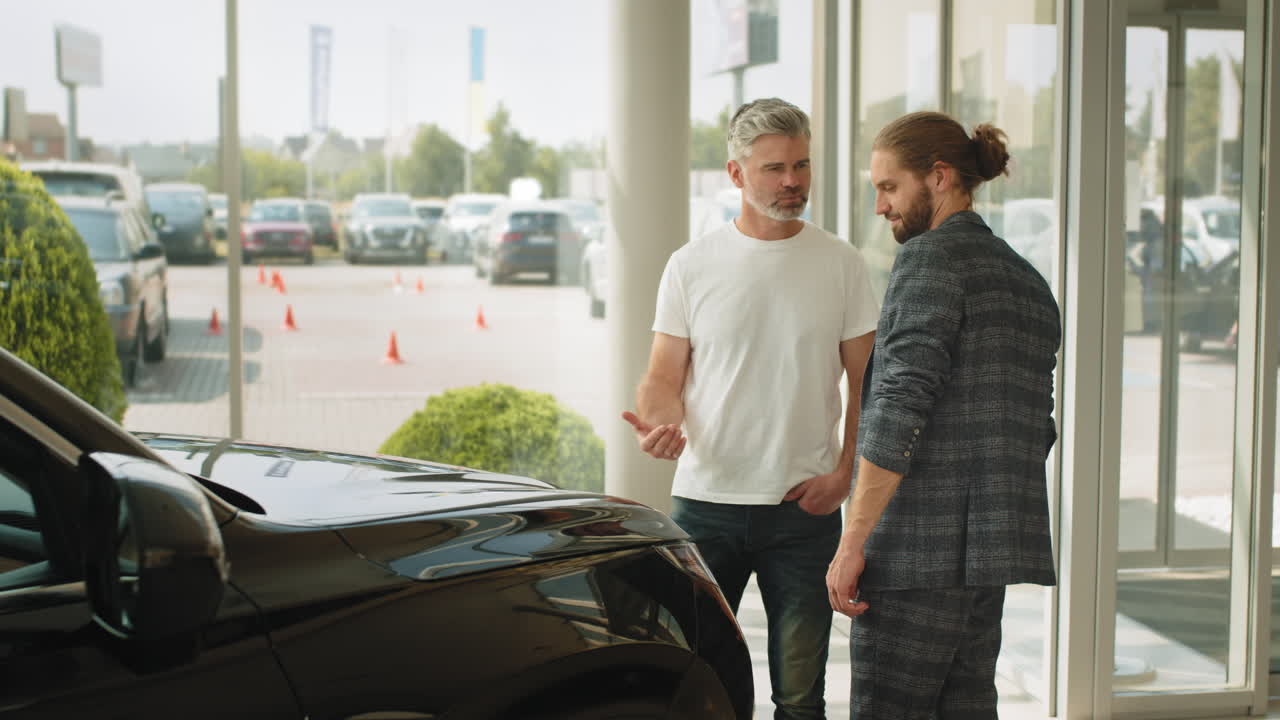 dos hombres discutiendo una compra de coche en una sala de exposiciones