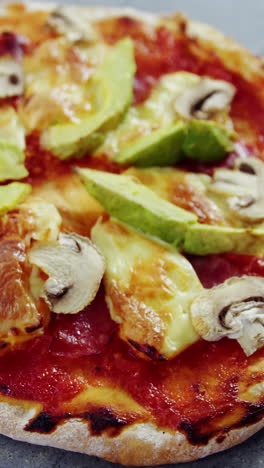 pizza al horno con aderezos de aguacate y hongos
