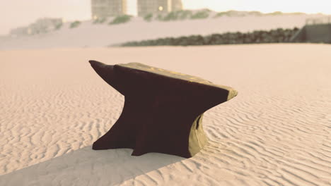 anvil positioned on sandy surface during low tide at coastal area