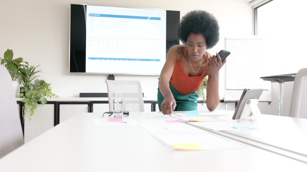 African american casual businesswoman and talking on smartphone in board room, slow motion