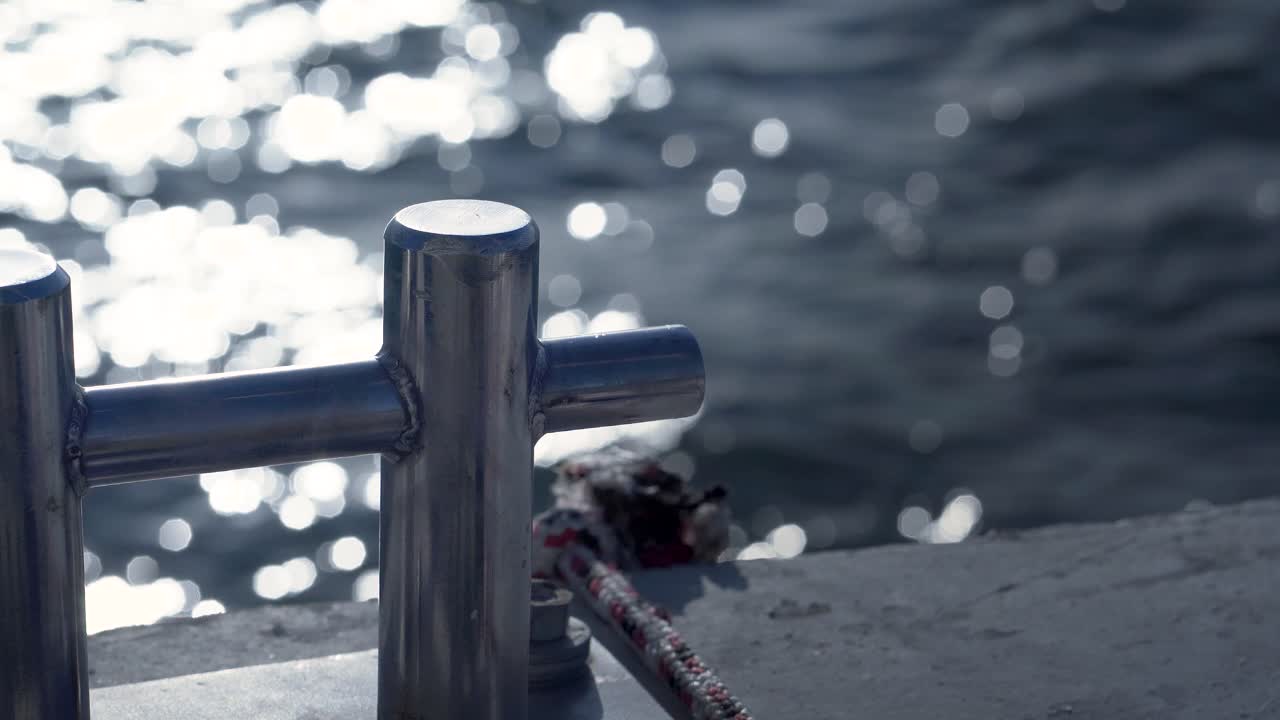 일몰의 배경에서 바다의 움직임과 함께 항구 계류 로프