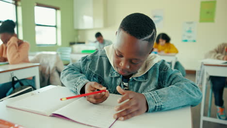 a young student is writing in a classroom