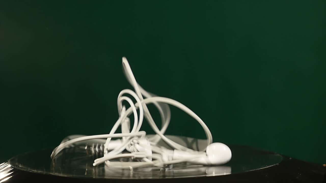 los auriculares saltan en el subwoofer en movimiento en el fondo verde