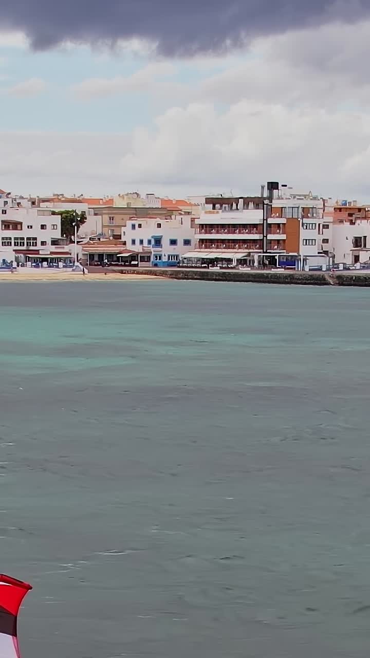 Windsurfisti cavalcano le onde nelle Isole Canarie, Spagna, in una giornata di sole