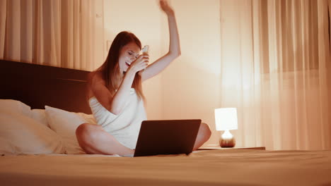 mujer en la cama usando una computadora portátil
