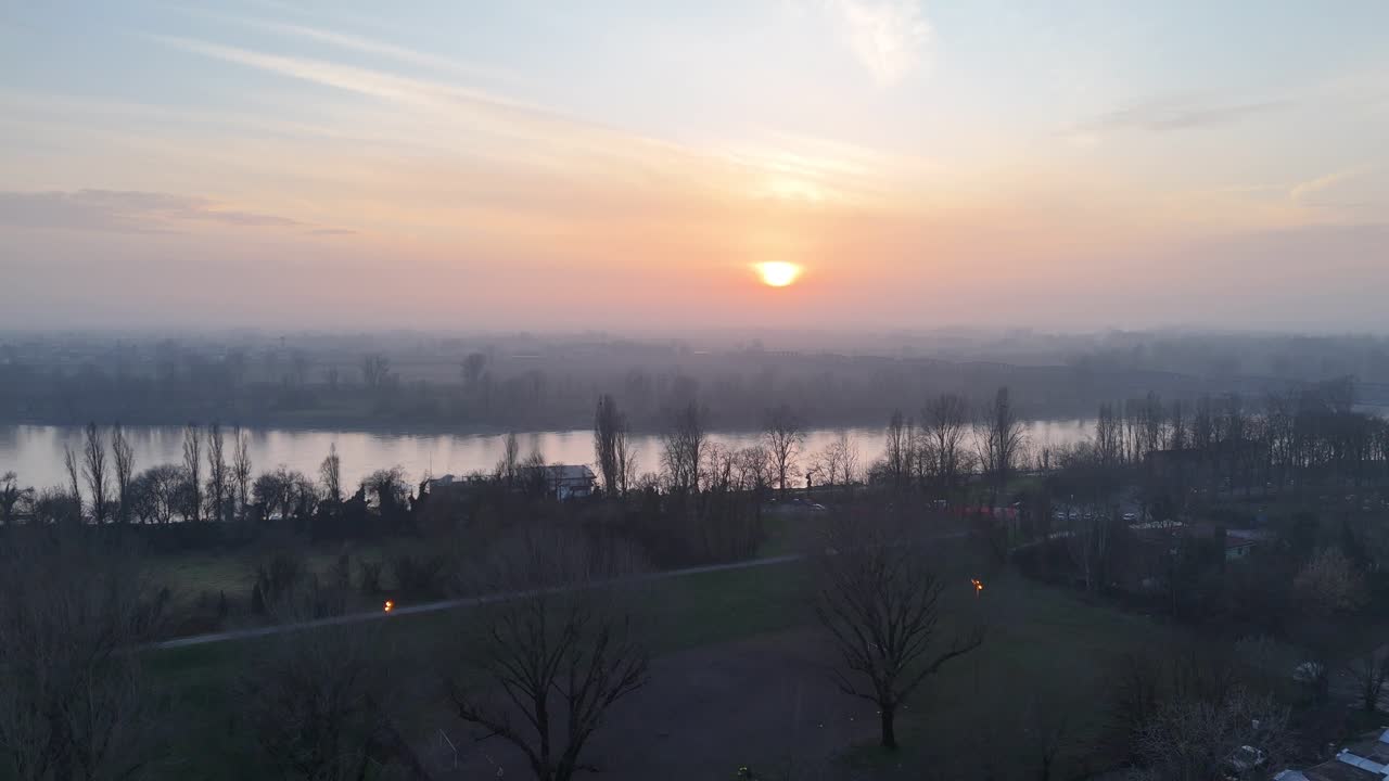 Luftsekvens som glir over Po-elven ved solnedgang, med det rolige vinterlandskapet i Cremona-provinsen