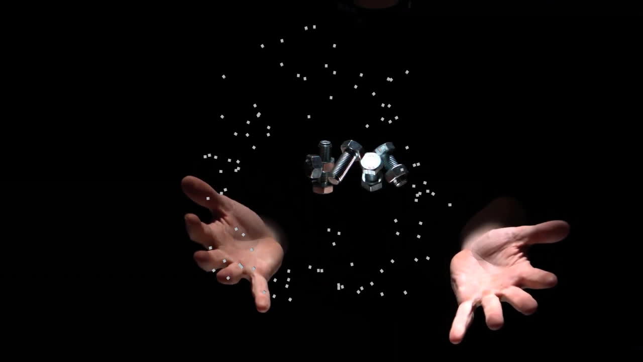 손은 견과류와 볼트를 들고, 떠다니는 입자 애니메이션으로 둘러싸여 있습니다.