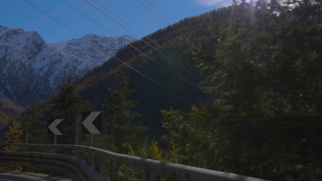 travelling to snow-capped mountains by road, forest passing, following street  arrow signs.