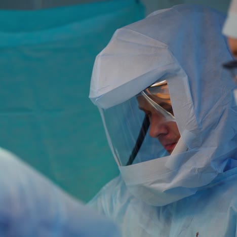 doctors in protective uniform. surgeon perform a surgery together with medical specialists. surgical procedure in clinic.