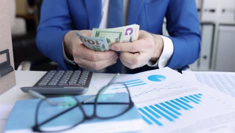 hombre de negocios contando dinero en la mesa con documentos y calculadora película 4k