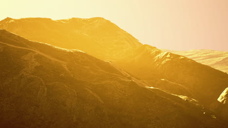 golden hue over mountain ranges at sunrise captures serene landscape beauty