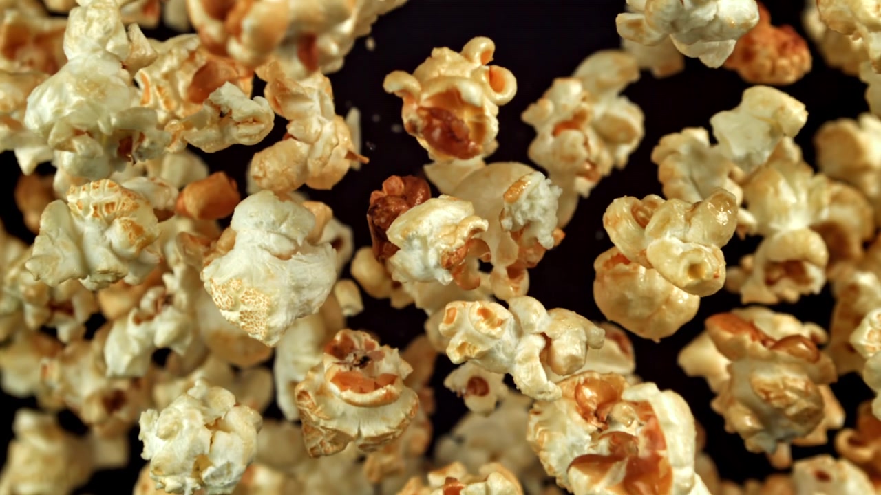 Popcorn che cadono in super slow motion su sfondo nero