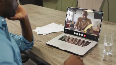 African-american-man-using-laptop-for-video-call,-with-business-colleague-on-screen