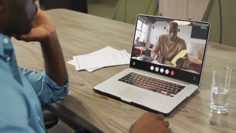 african american man using laptop for video call, with business colleague on screen
