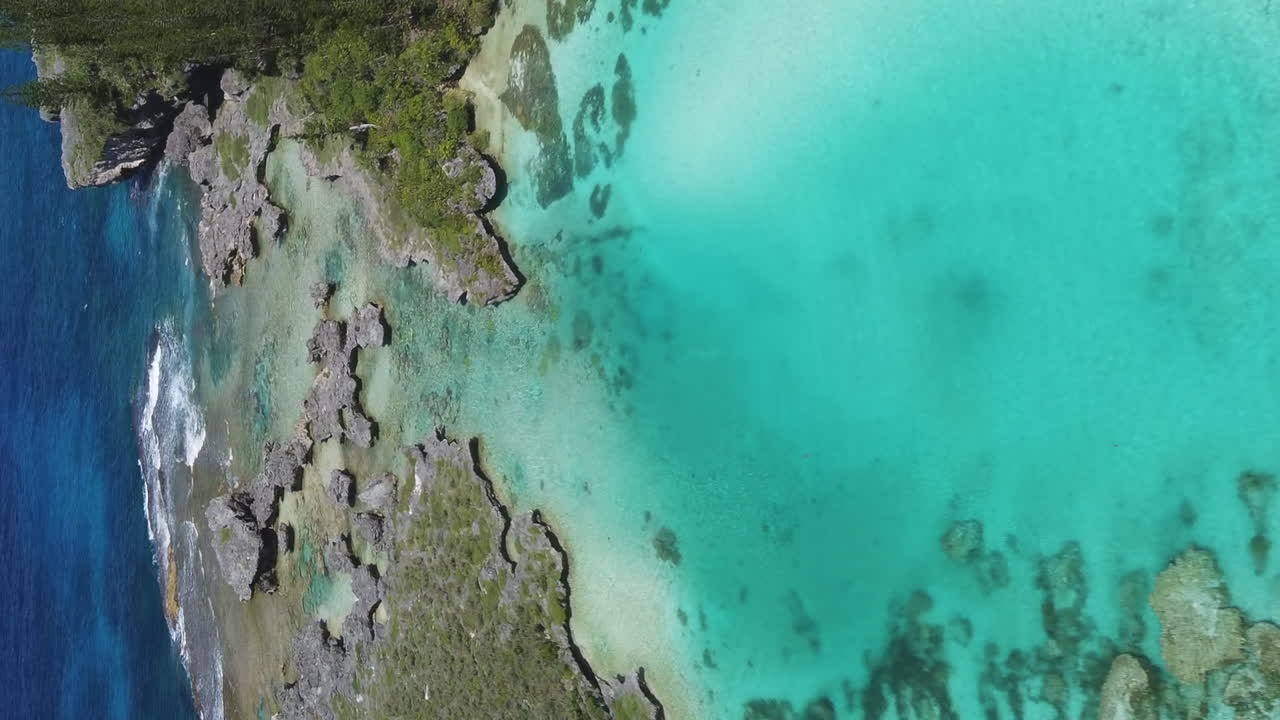 Isle of Pines at Oro Bay along the the shallow shores by the Natural Pool - vertical aerial