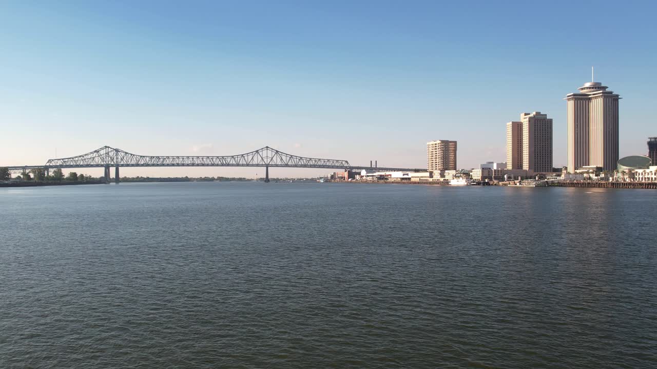 미시시피 강을 따라 크레센트 시티 연결 다리를 향해 뉴올리언스 위를 날아다니는 공중 드론, 오른쪽에 있는 건물을 지나
