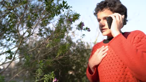 adolescente hablando en un dispositivo móvil al aire libre