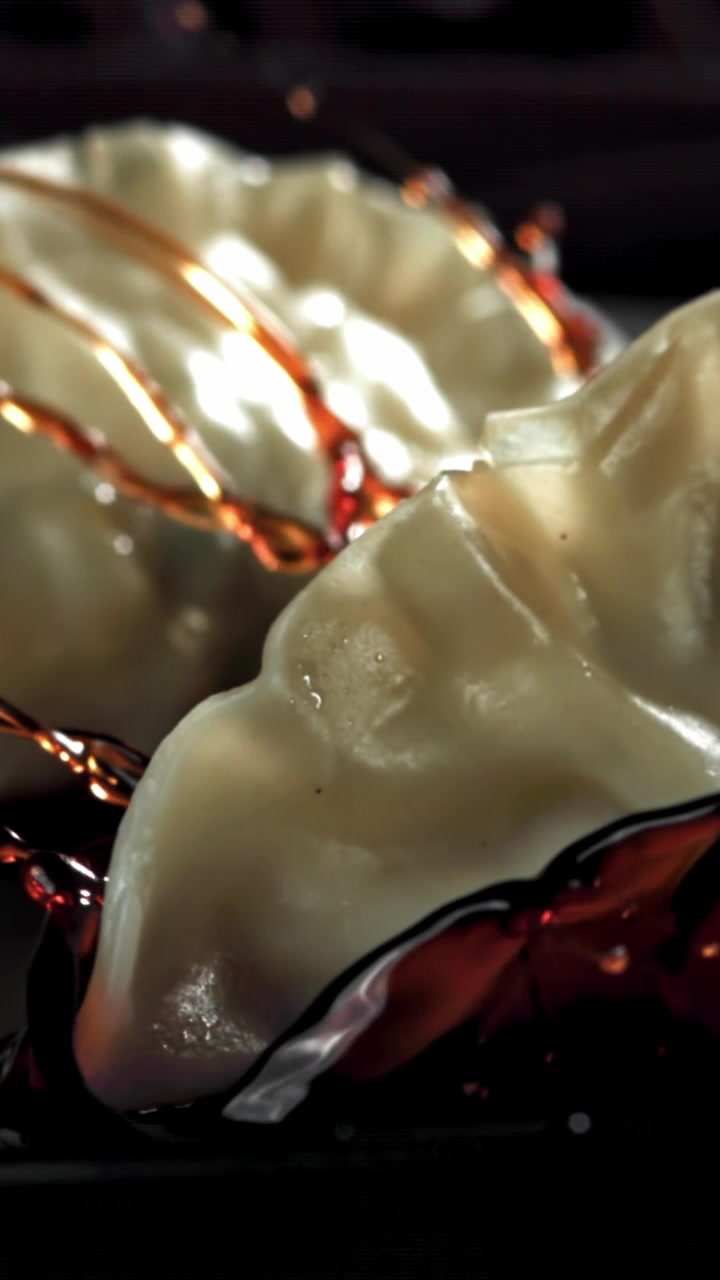 Slow Motion of Soy Sauce Splashing on Freshly Cooked Dumplings