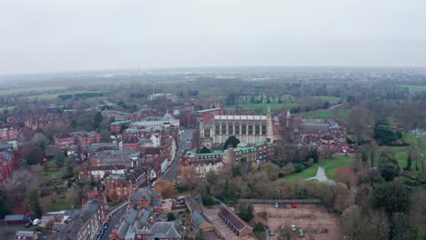 dolly forward aerial drone shot of eton college chapel and village on a cloudy day