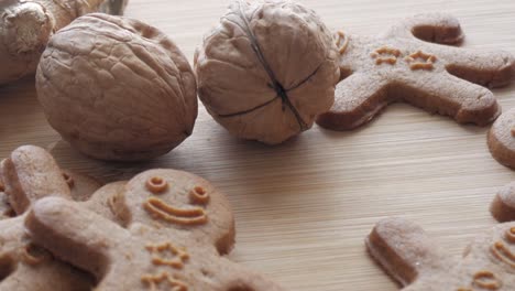 panning view of gingerbread men cookies on a table with walnuts. close-up