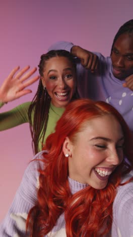 Vertical-Video-Studio-Shot-Of-Gen-Z-Friends-Dancing-And-Posing-For-Selfie-At-Party-Or-Club-On-Mobile-Phone-1