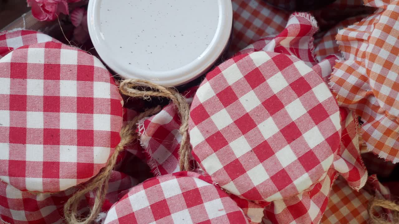 primer plano de frascos de mermelada cubiertos de jengibre rojo y blanco