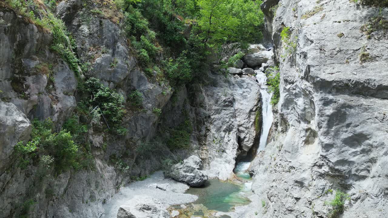 Aerial drone footage of Gole Ranciara, Sicily: rocky canyon with turquoise river, lush vegetation, and dramatic cliffs. Perfect for nature, adventure, and travel documentary projects
