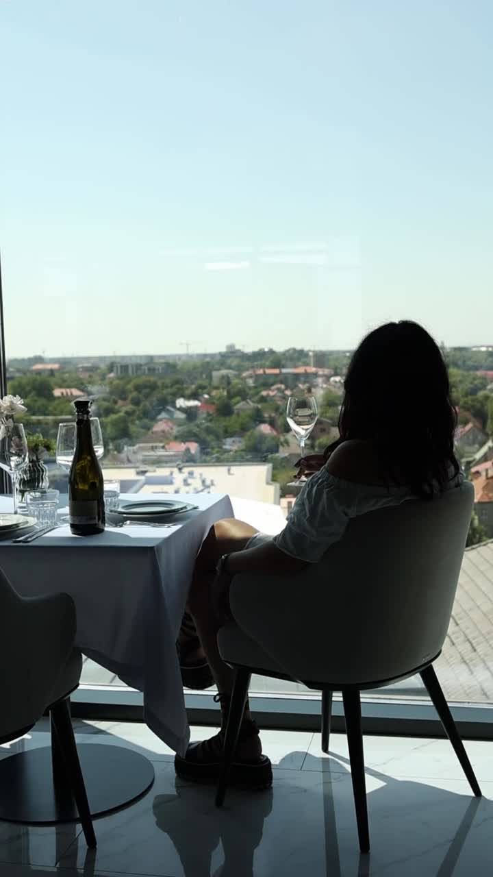 Woman enjoying wine with a city view