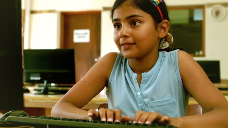 cute little pupil looking at laptop in classroom