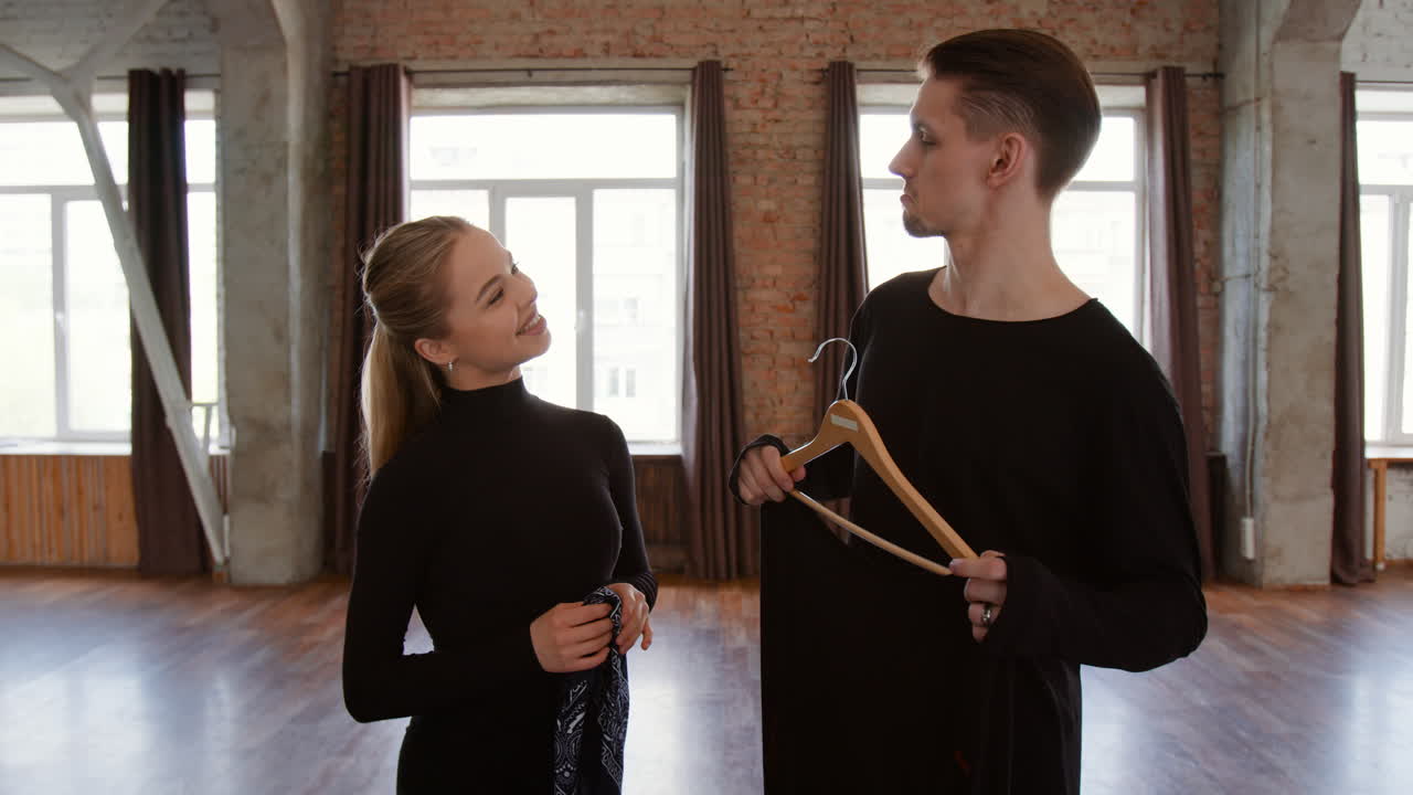 Man and woman discussing clothing in a spacious studio