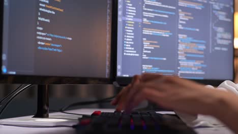 close up of female programmer's hands typing on desktop computer creating software engineer developing app, program, video game at home. terminal with coding language