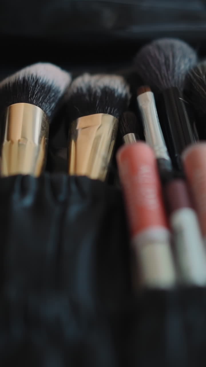 Organizer with soft makeup brushes on workplace of visage master in cosmetology salon extreme closeup. Supplies to apply decorative cosmetics