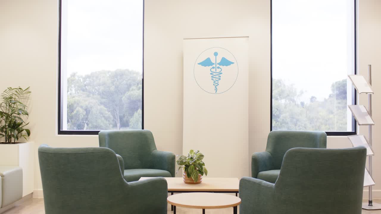 De camera trekt zich terug in de medische wachtkamer en onthult blauwgroene fauteuils en een banner om de lay-out te laten zien