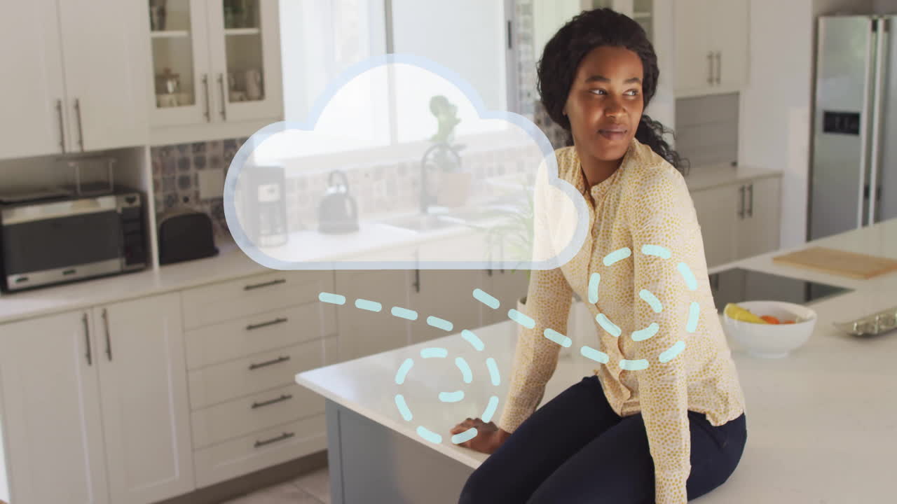 Woman sitting on kitchen counter with cloud and network animation overlay